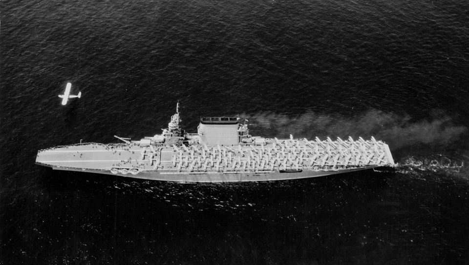 A P2Y-1 flying over the USS Lexington.